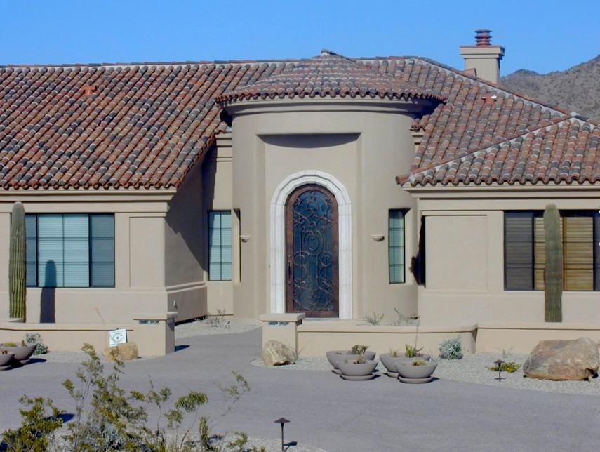 Inspiration for a mid-sized one-storey adobe beige exterior in Phoenix with a hip roof.