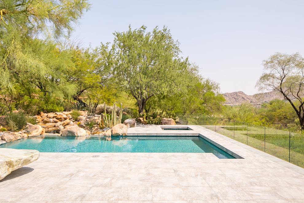 Photo of a backyard rectangular lap pool in Phoenix with tile.