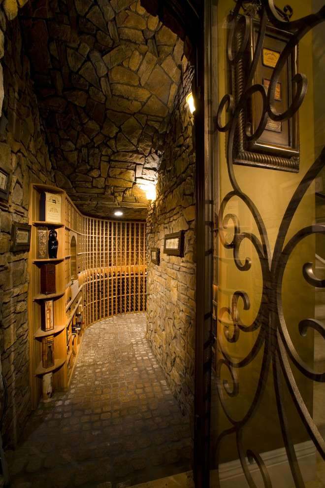 This is an example of an expansive mediterranean wine cellar in Las Vegas with storage racks, brick floors and beige floor.