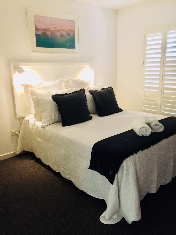 Small nautical guest bedroom in Sunshine Coast with white walls, carpet and grey floors.