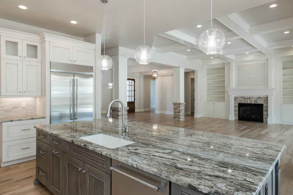 Inspiration for a large transitional l-shaped light wood floor and brown floor eat-in kitchen remodel in Denver with an undermount sink, flat-panel cabinets, gray cabinets, granite countertops, beige backsplash, stainless steel appliances, an island and gray countertops