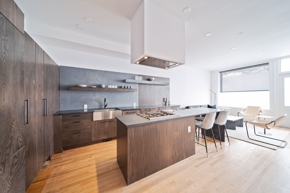 Eat-in kitchen - mid-sized contemporary l-shaped beige floor eat-in kitchen idea in Newark with a farmhouse sink, flat-panel cabinets, dark wood cabinets, soapstone countertops, an island and gray countertops