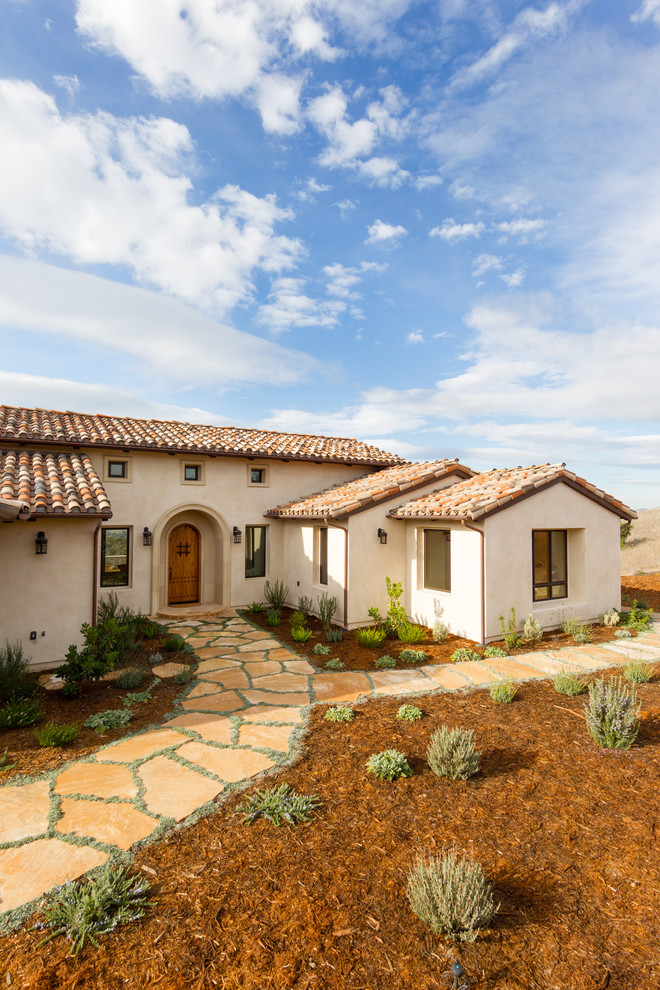 Photo of a mid-sized mediterranean one-storey stucco beige exterior in San Luis Obispo with a gable roof.