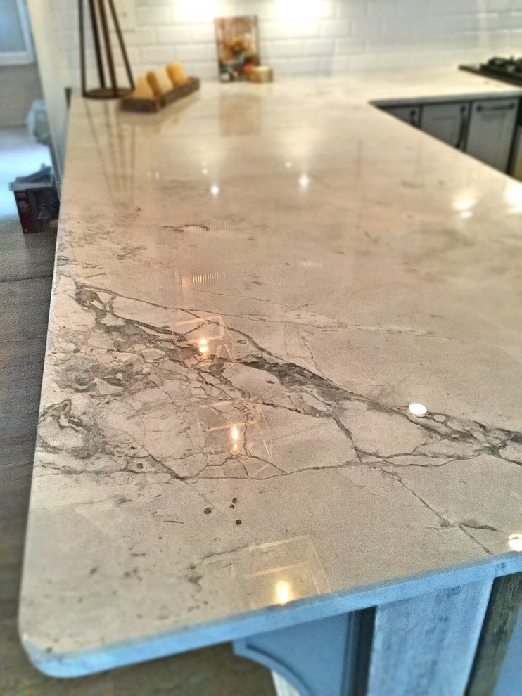 Inspiration for a mid-sized rustic u-shaped light wood floor open concept kitchen remodel in Atlanta with a farmhouse sink, shaker cabinets, gray cabinets, quartzite countertops, white backsplash, subway tile backsplash, stainless steel appliances and a peninsula