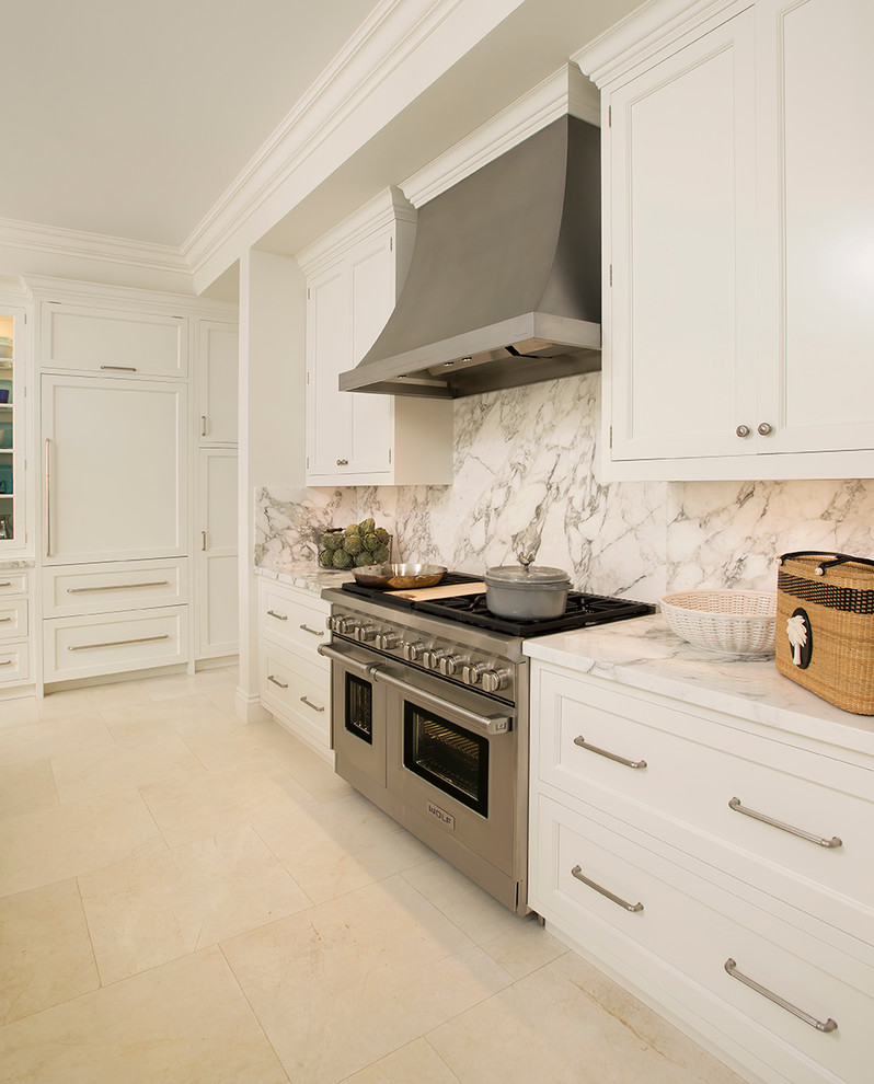 Mid-sized transitional l-shaped eat-in kitchen in Miami with a farmhouse sink, white cabinets, stainless steel appliances, with island, recessed-panel cabinets, marble benchtops, multi-coloured splashback and marble floors.