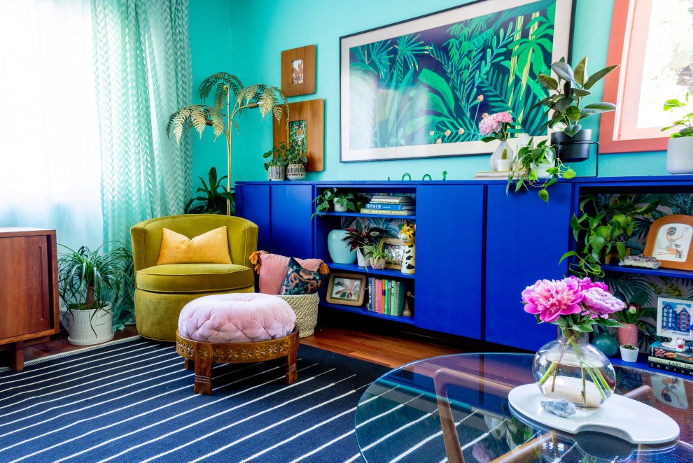 サンディエゴにある高級な中くらいなトロピカルスタイルのおしゃれな独立型リビング (青い壁、無垢フローリング、壁掛け型テレビ、パネル壁、赤い床) の写真
