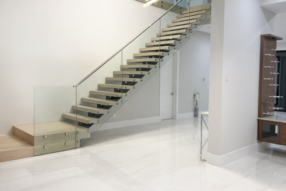 Design ideas for a large modern wood straight staircase in Miami with open risers.