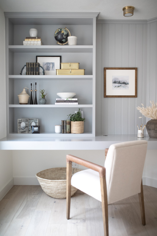 Photo of a small beach style home office in Orange County with grey walls, light hardwood floors and a built-in desk.