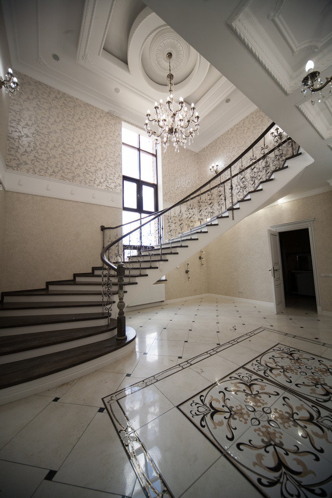 Бетонная лестница со ступенями из дуба и кованными балясинаями