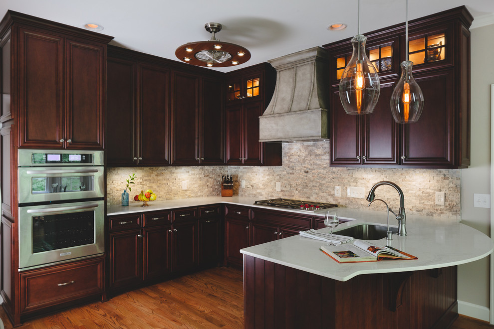 Example of a large transitional u-shaped medium tone wood floor eat-in kitchen design in Atlanta with an undermount sink, raised-panel cabinets, dark wood cabinets, quartz countertops, gray backsplash, stone tile backsplash, stainless steel appliances and no island
