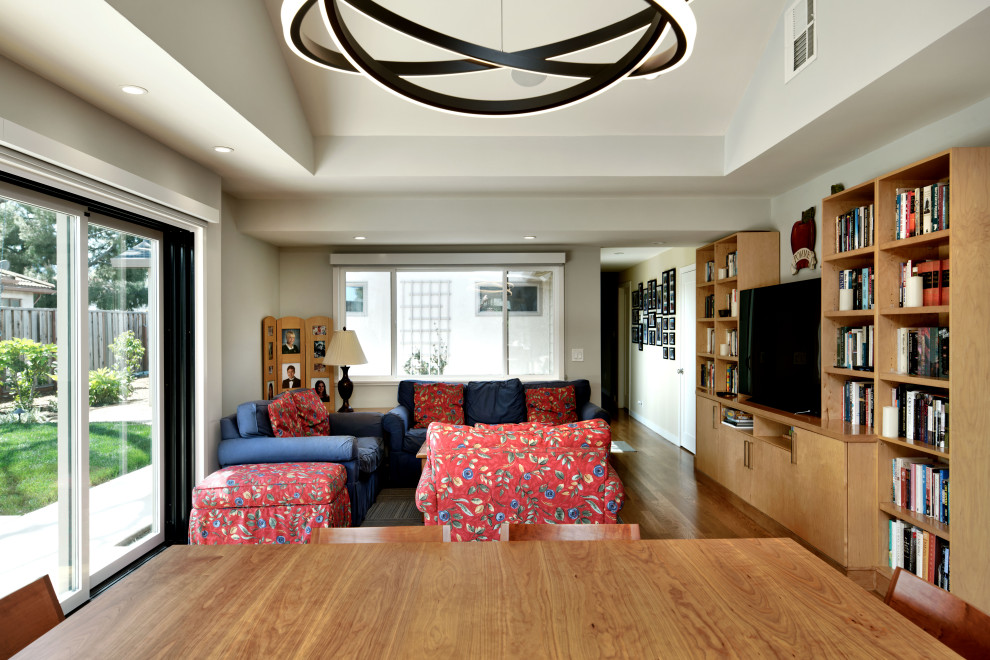 Foto di un soggiorno tradizionale di medie dimensioni e aperto con pareti grigie, pavimento in legno massello medio, pavimento marrone, soffitto a volta e TV autoportante
