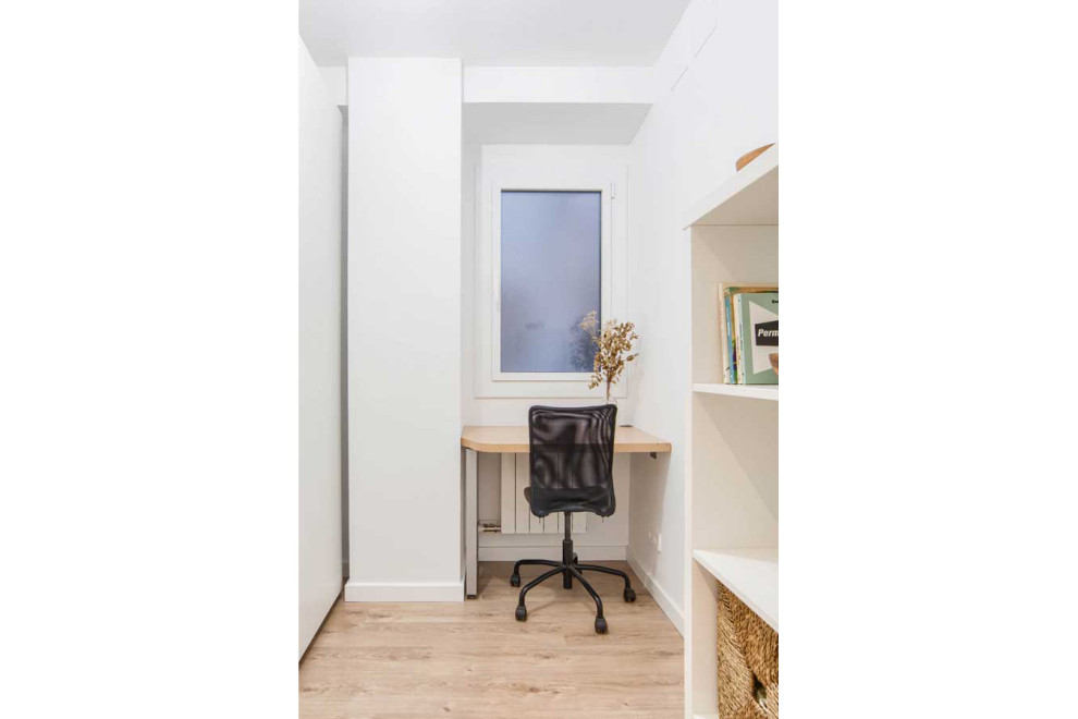 Ejemplo de estudio nórdico pequeño con paredes blancas, suelo de madera en tonos medios, escritorio empotrado y suelo marrón