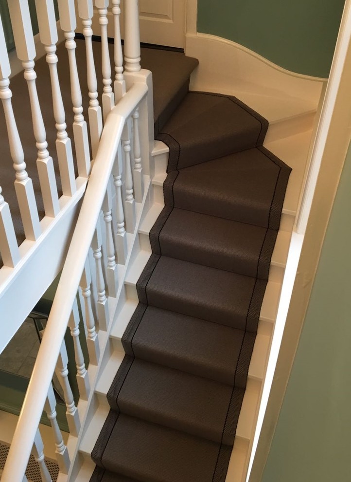 Ejemplo de escalera en L clásica de tamaño medio con escalones de madera, contrahuellas de madera y barandilla de madera