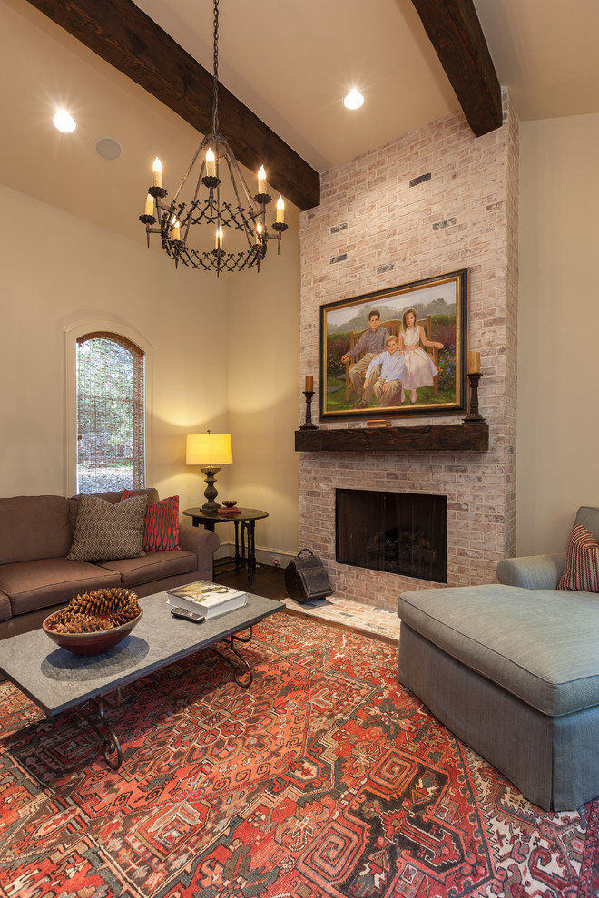 Photo of an expansive traditional enclosed family room in Houston with white walls, dark hardwood floors, a standard fireplace, a brick fireplace surround, no tv and brown floor.