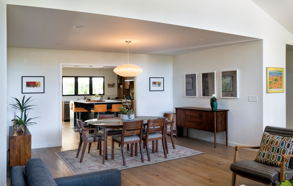 Idee per una sala da pranzo aperta verso la cucina minimalista di medie dimensioni con parquet chiaro, pavimento marrone e pareti bianche