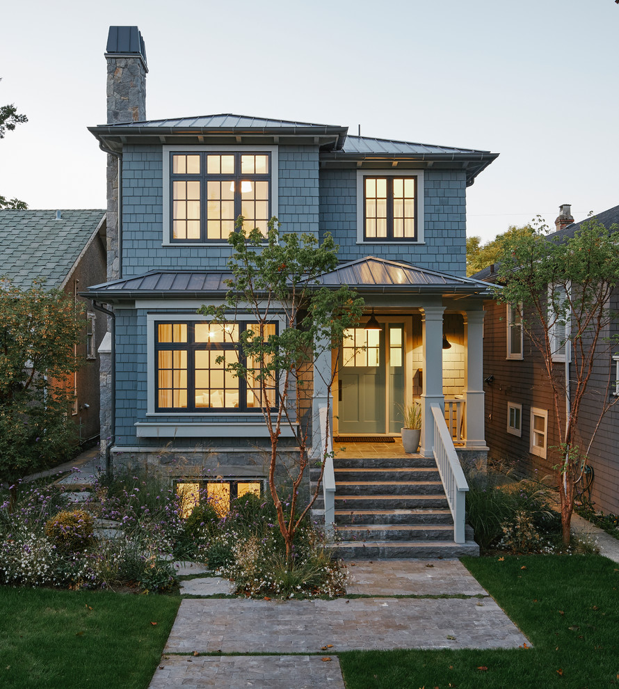 Mid-sized traditional two-storey blue house exterior in Vancouver with wood siding, a hip roof and a metal roof.