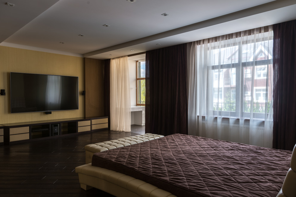 Photo of a large master bedroom in Moscow with yellow walls, dark hardwood flooring, brown floors, a drop ceiling and feature lighting.