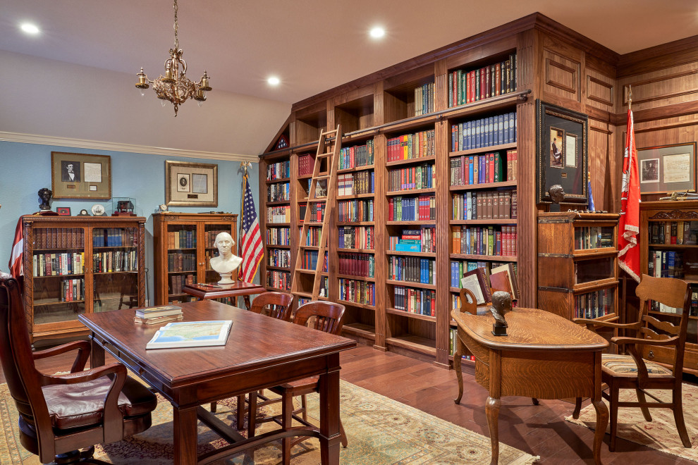Пример оригинального дизайна: большой домашняя библиотека в классическом стиле с синими стенами, паркетным полом среднего тона, отдельно стоящим рабочим столом и деревянными стенами