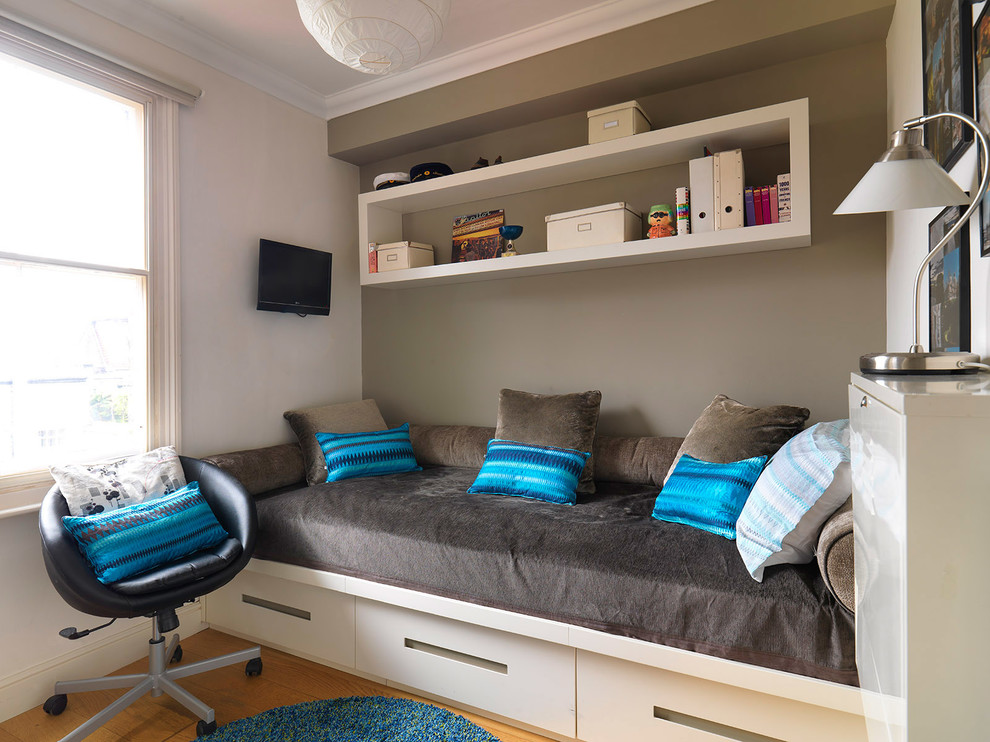 Photo of a mid-sized traditional kids' room for boys in London with grey walls and medium hardwood floors.