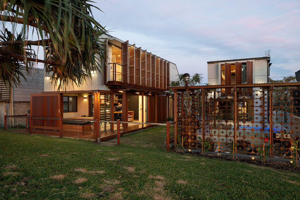 Inspiration for a beach style two-storey brown house exterior in Gold Coast - Tweed with mixed siding and a flat roof.