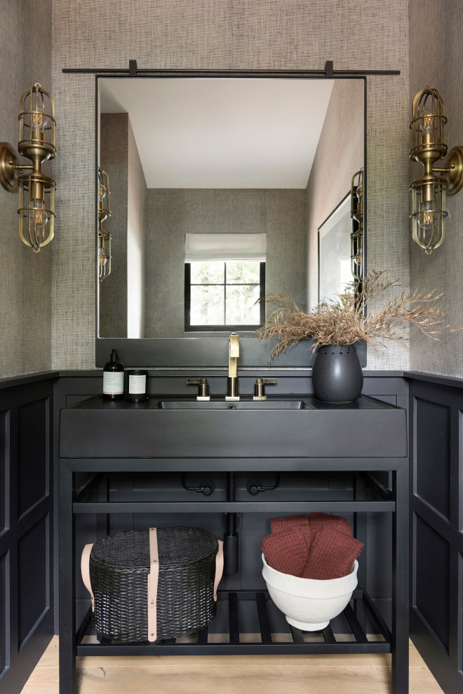 Inspiration for a coastal beige floor and wallpaper powder room remodel in Minneapolis with open cabinets, black cabinets, brown walls, an integrated sink, black countertops and a freestanding vanity