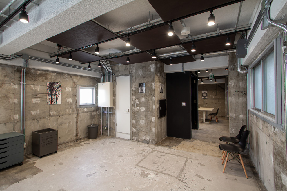 Exemple d'un bureau industriel de taille moyenne et de type studio avec un mur gris, sol en béton ciré, aucune cheminée, un bureau indépendant, un sol gris et un plafond à caissons.