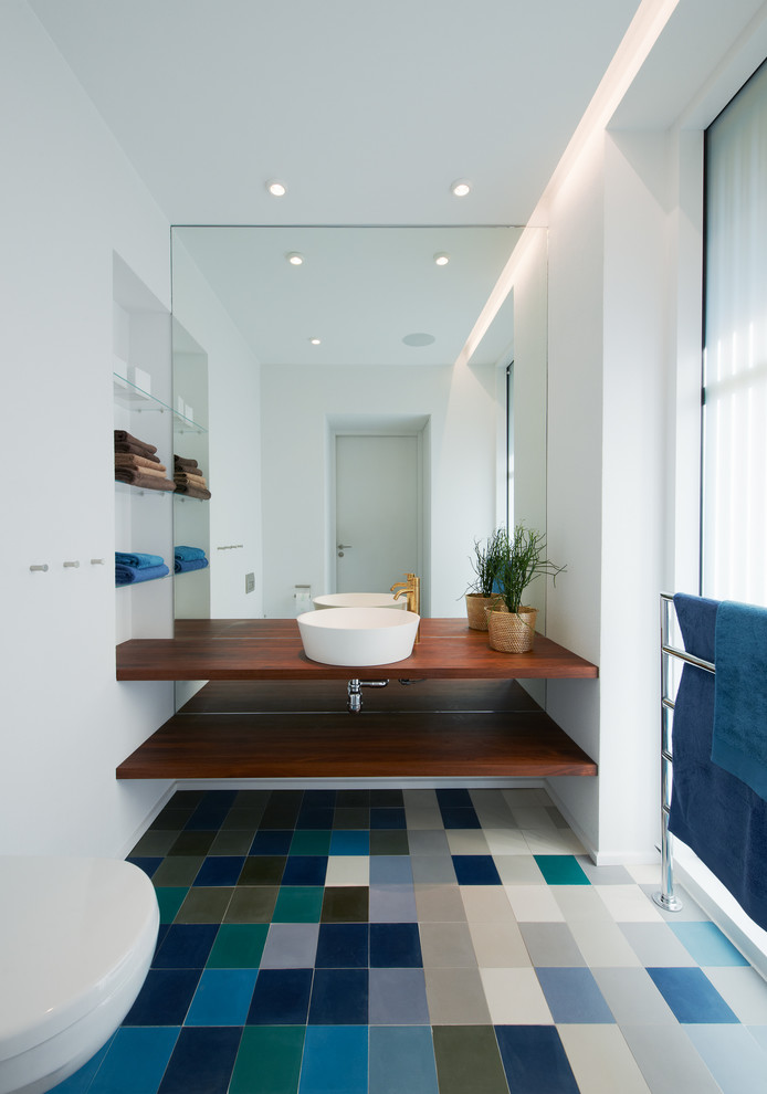 Inspiration for a mid-sized scandinavian powder room in Stockholm with a vessel sink, wood benchtops, white walls, open cabinets, dark wood cabinets, multi-coloured tile, ceramic floors, multi-coloured floor and brown benchtops.