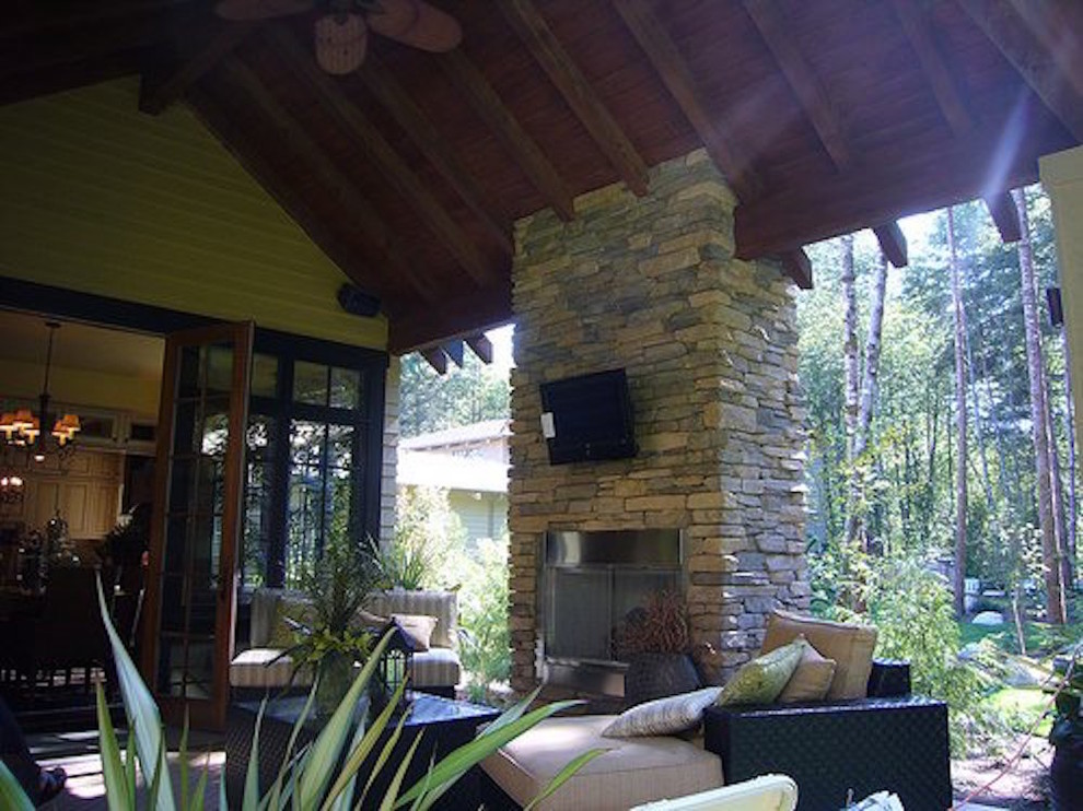 Patio - large transitional backyard stone patio idea in Orange County with a fire pit and a roof extension