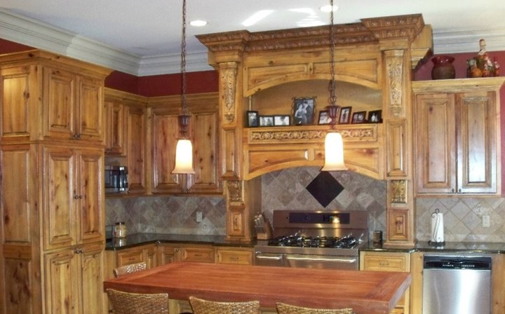 Inspiration for a mid-sized rustic kitchen remodel in Minneapolis with raised-panel cabinets, dark wood cabinets, solid surface countertops, multicolored backsplash, ceramic backsplash and an island