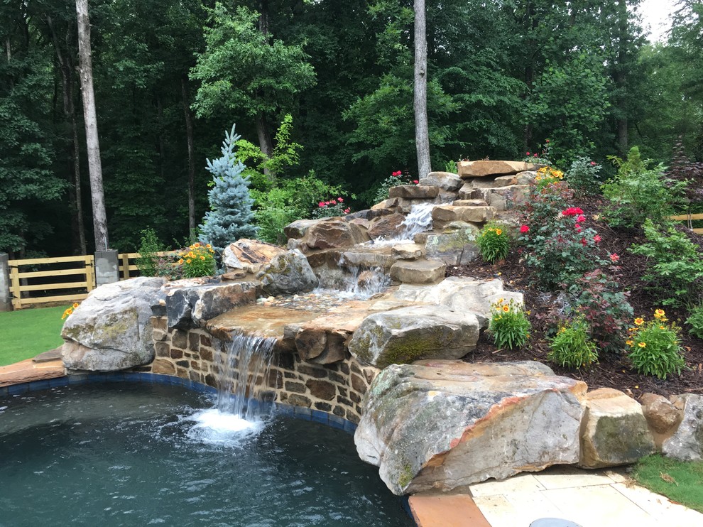 Design ideas for an expansive tropical backyard natural pool in Atlanta.