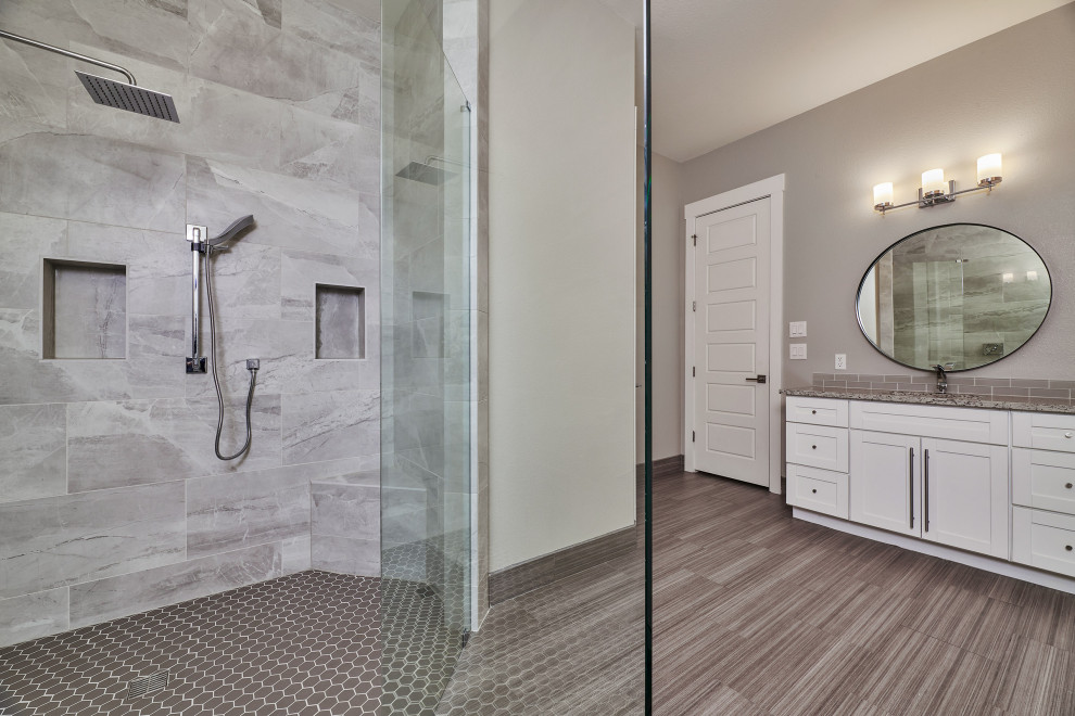 Transitional gray tile and porcelain tile porcelain tile, brown floor and double-sink walk-in shower photo with shaker cabinets, white cabinets, beige walls, an undermount sink, granite countertops, beige countertops and a built-in vanity