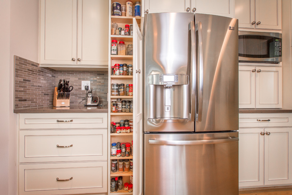 Transitional u-shaped kitchen photo in DC Metro with an undermount sink, flat-panel cabinets, white cabinets, quartz countertops, gray backsplash and stainless steel appliances