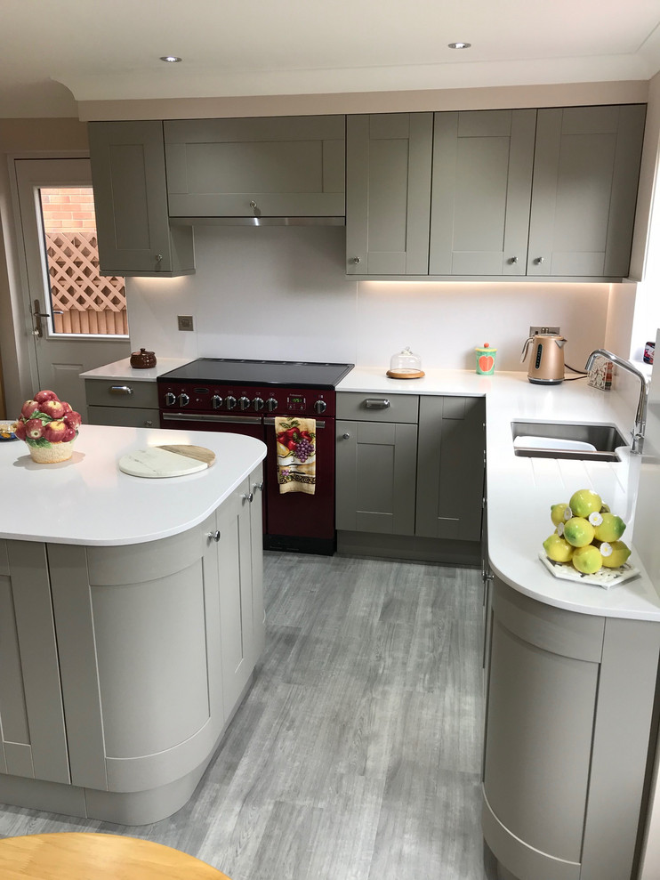 This is an example of a mid-sized traditional eat-in kitchen in Glasgow with an integrated sink, shaker cabinets, grey cabinets, quartzite benchtops, white splashback, coloured appliances, vinyl floors, with island, grey floor and white benchtop.