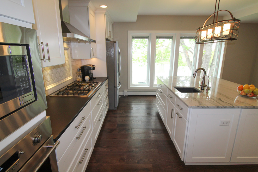 Kitchen - kitchen idea with an undermount sink, shaker cabinets, white cabinets, quartzite countertops, subway tile backsplash, stainless steel appliances and an island