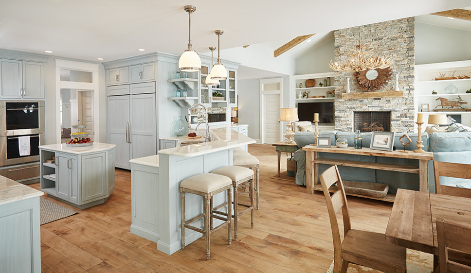 Inspiration for a large beach style u-shaped open plan kitchen in Grand Rapids with beaded inset cabinets, blue cabinets, marble benchtops, white splashback, stone tile splashback, panelled appliances, medium hardwood floors and with island.