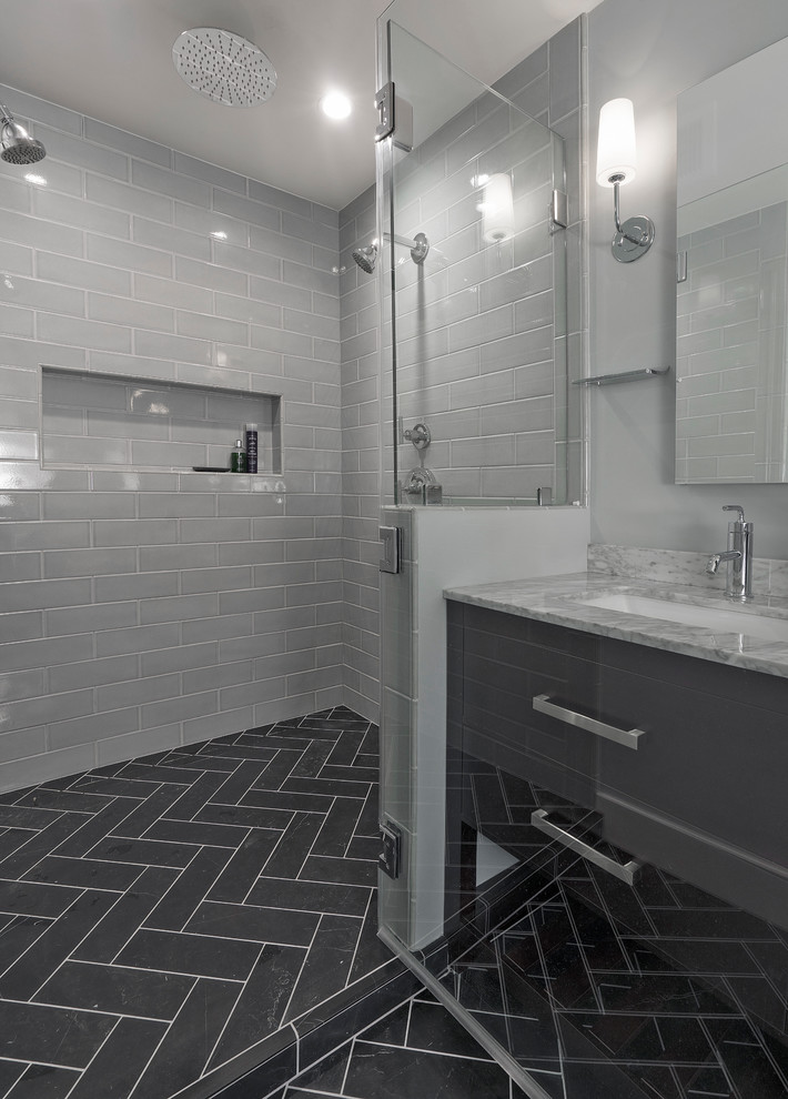 Photo of a mid-sized transitional 3/4 bathroom in DC Metro with brown cabinets, a one-piece toilet, white tile, subway tile, grey walls, ceramic floors, an undermount sink, engineered quartz benchtops, black floor, a hinged shower door, white benchtops, an alcove shower and flat-panel cabinets.