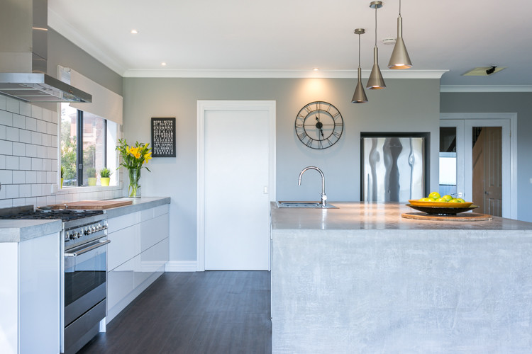 This is an example of an expansive contemporary galley eat-in kitchen in Melbourne with a double-bowl sink, open cabinets, white cabinets, concrete benchtops, white splashback, subway tile splashback, stainless steel appliances and with island.