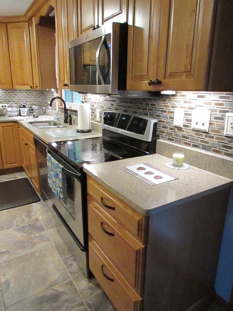 Mid-sized transitional l-shaped ceramic tile home design photo with a double-bowl sink, raised-panel cabinets, light wood cabinets, quartz countertops, multicolored backsplash, mosaic tile backsplash, stainless steel appliances and an island