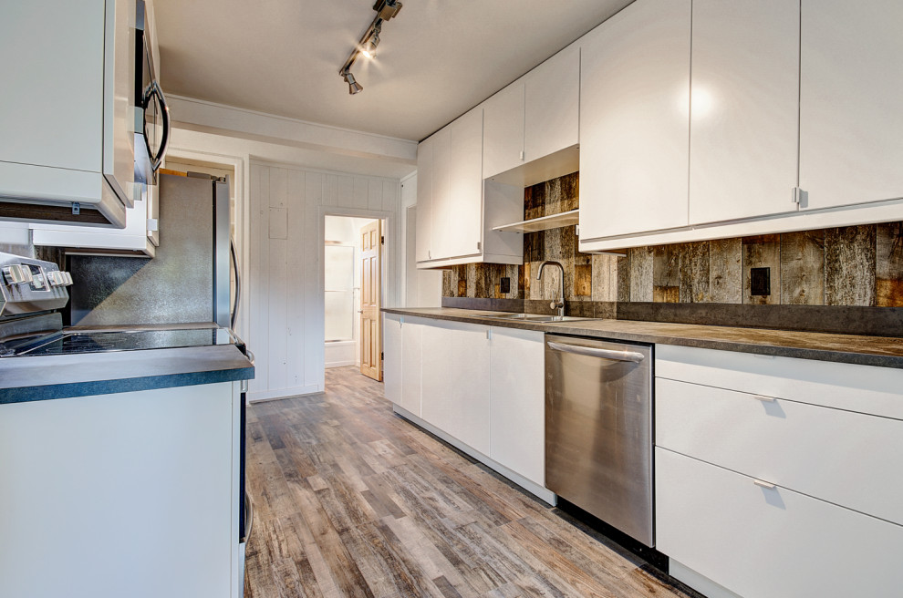 Inspiration for a mid-sized rustic galley medium tone wood floor and brown floor kitchen remodel in Denver with a drop-in sink, flat-panel cabinets, white cabinets, concrete countertops, brown backsplash, wood backsplash, stainless steel appliances, no island and brown countertops