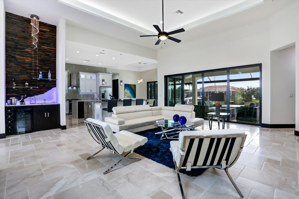 Inspiration for a large transitional open concept living room in Miami with white walls, travertine floors, a standard fireplace, a stone fireplace surround and a built-in media wall.