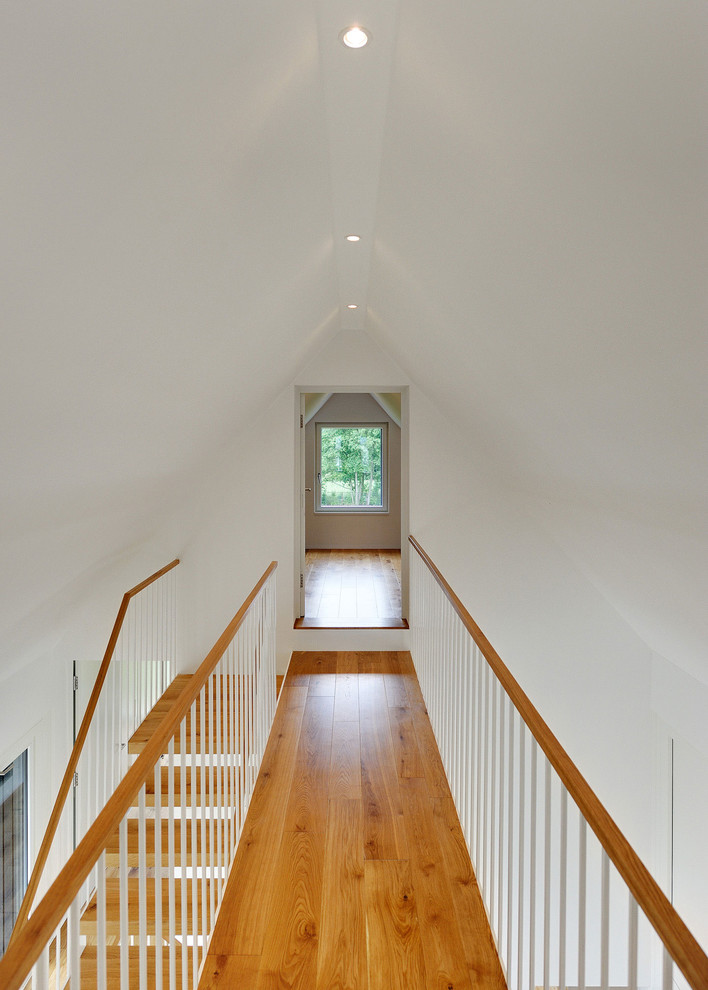This is an example of a mid-sized contemporary hallway in Berlin with white walls and medium hardwood floors.
