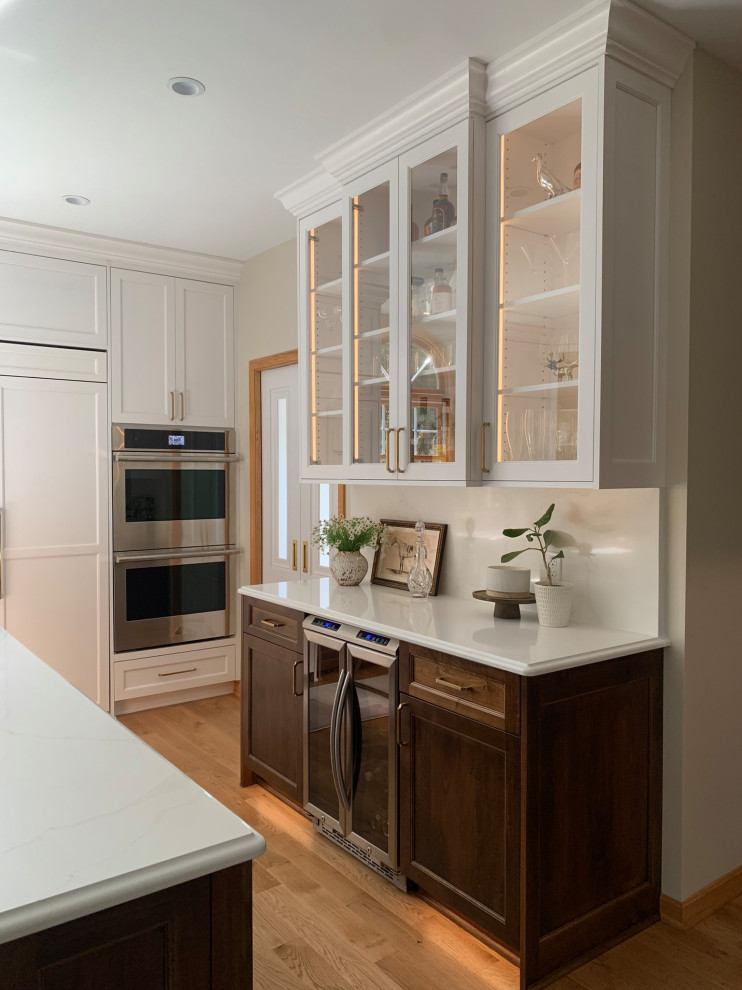 Kitchen - light wood floor kitchen idea with a double-bowl sink, shaker cabinets, white cabinets, quartz countertops, quartz backsplash, paneled appliances and an island