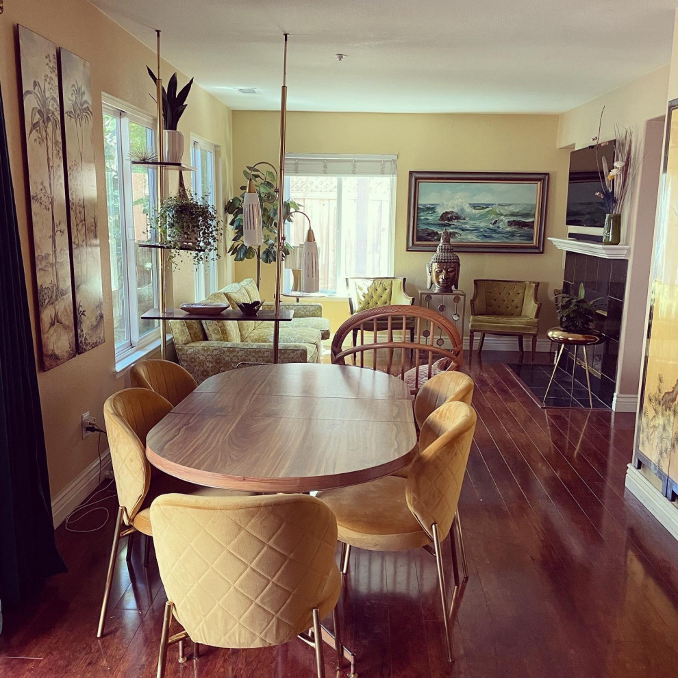 Mittelgroßes, Offenes Retro Wohnzimmer mit gelber Wandfarbe, Laminat, TV-Wand und braunem Boden in Orange County