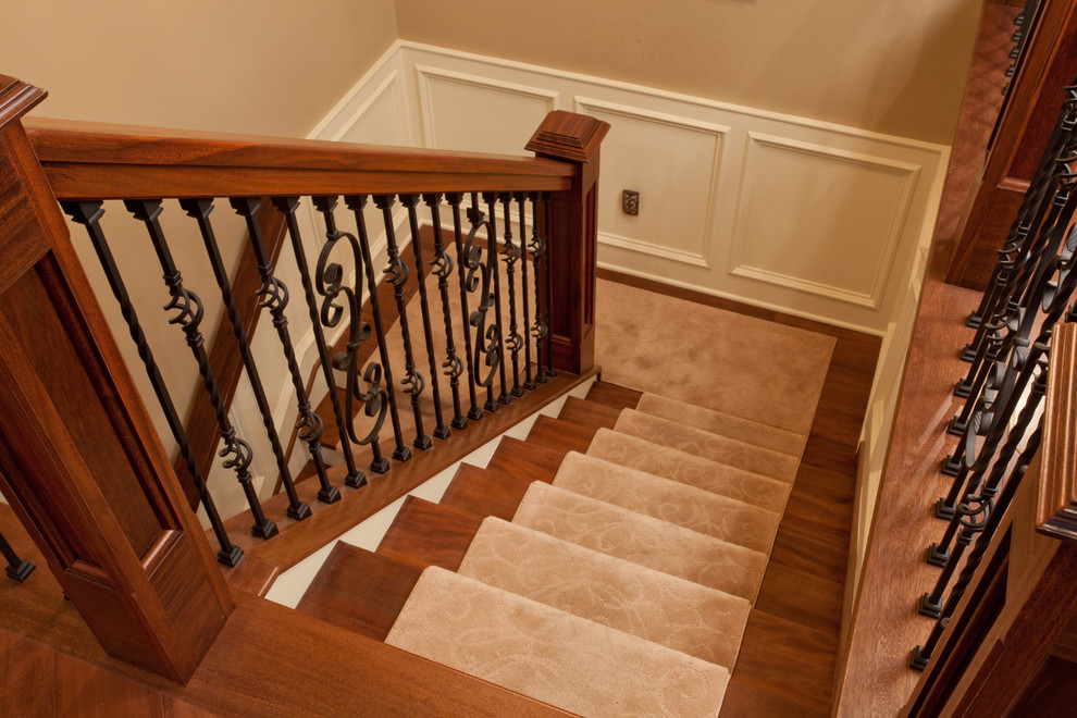 Photo of a large traditional wood l-shaped staircase in St Louis with carpet risers.