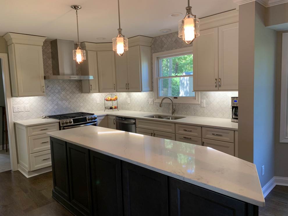 Mid-sized transitional l-shaped medium tone wood floor and brown floor eat-in kitchen photo in Cincinnati with an undermount sink, flat-panel cabinets, white cabinets, quartz countertops, white backsplash, marble backsplash, stainless steel appliances, an island and white countertops