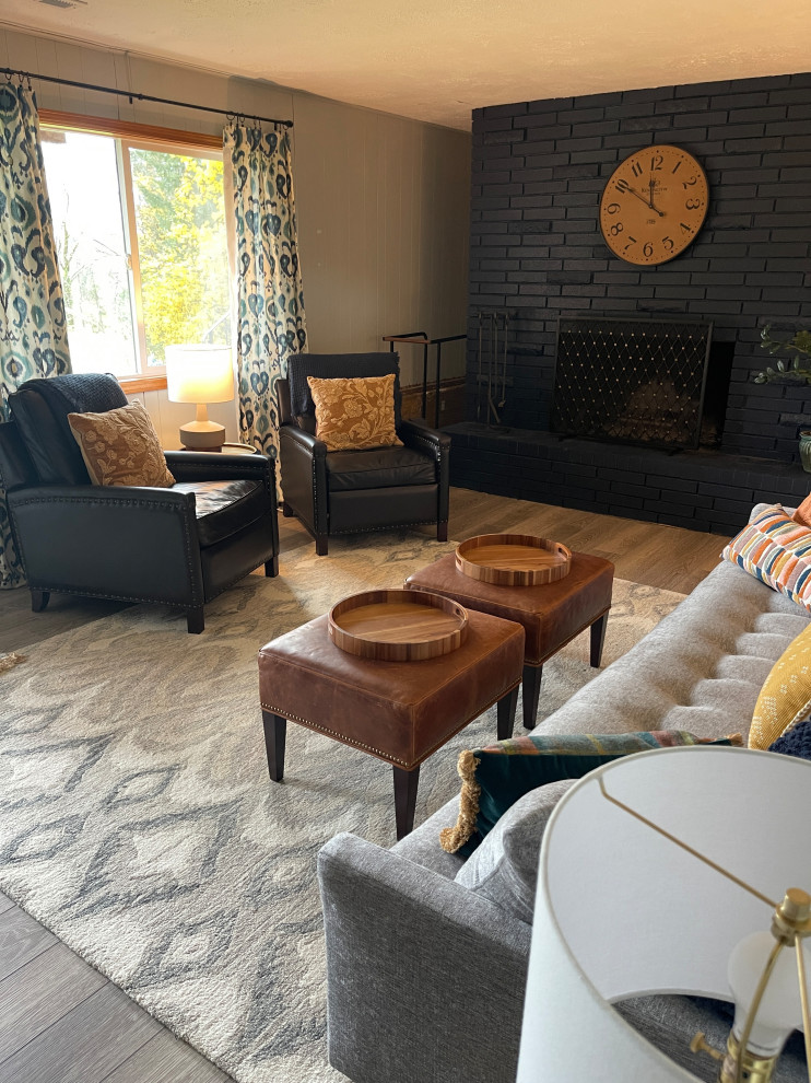 Photo of a mid-sized transitional enclosed family room in Portland with grey walls, a standard fireplace, a brick fireplace surround, grey floor and panelled walls.