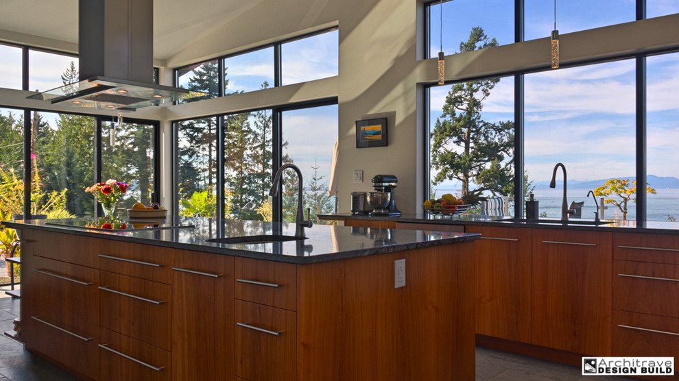 Photo of a mid-sized contemporary kitchen in Vancouver with a single-bowl sink, flat-panel cabinets, medium wood cabinets, granite benchtops, stainless steel appliances, slate floors and with island.