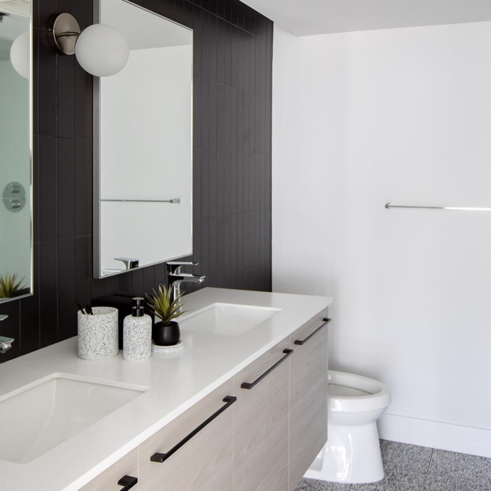 This is an example of a small modern master bathroom in Vancouver with flat-panel cabinets, grey cabinets, black tile, ceramic tile, terrazzo floors, laminate benchtops and white benchtops.