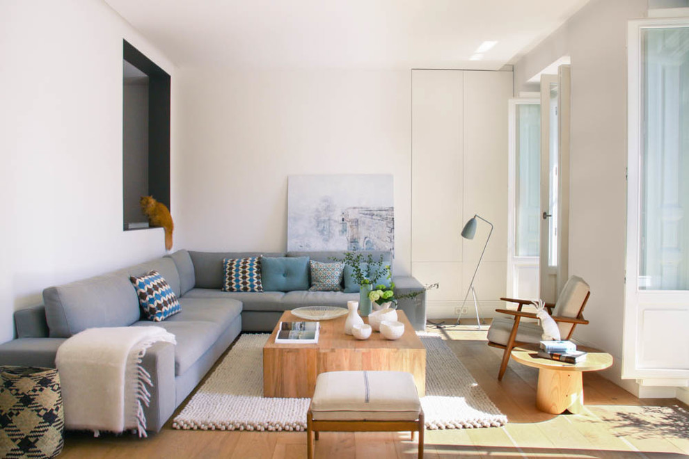 Small danish formal and enclosed medium tone wood floor living room photo in Madrid with white walls, no fireplace and no tv