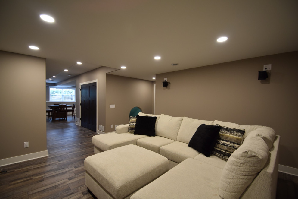 Inspiration for a large transitional underground vinyl floor and multicolored floor basement remodel with a bar and beige walls
